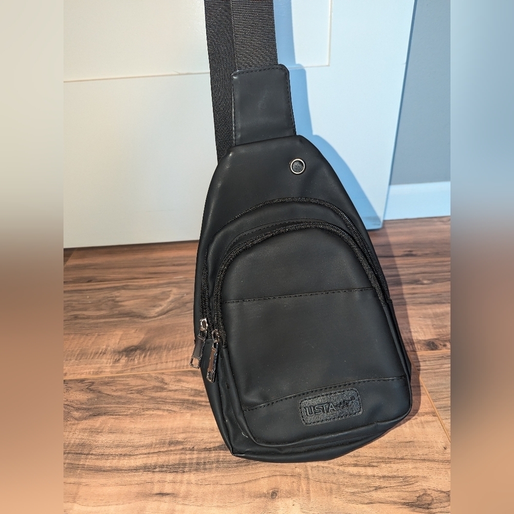 USTA brand sling backpack with adjustable strap in black. Black sling.